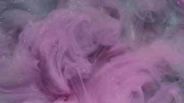 Parıldayan mürekkep. Işıl ışıl parlayan boya. Odaklanmamış pembe mavi renk su sıçrama pigmenti soyut beyaz sanat arka planına yayılıyor.