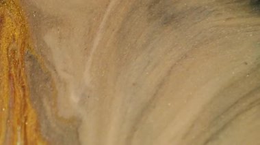 Altın parıltılı mürekkep. Işıl ışıl. Soyut akrilik sanat arka planına odaksız sarı mor renk parçacıkları pigment dökülmesi.