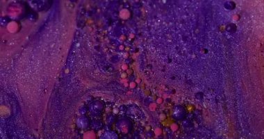 Baloncuk sanatı. Parıldayan yağ. Odaklanmamış pembe turuncu renkli ışıltılı mürekkep sıvısı soyut, canlı arka planda yüzüyor..