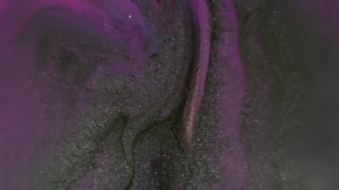 Bulanık boya sıvısı. Parlak sıvı. Odaklanmamış neon pembe renk parçacıkları soyut akrilik sanat arka planında koyu siyah doku dökülmesi.