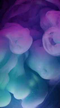 Dikey video. Sis patlaması. Dumanı karıştır. Siyah bulanık dokuya dökülen mor yeşil boya sıvısı. Sanat karışımı neon rengi soyut akış odaklı olmayan arkaplan.