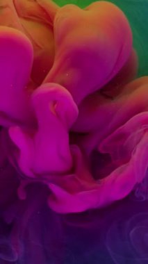 Dikey video. Dalga sisi. Duman spreyi. Turkuaz sıvıda parlak pembe sıvı patladı. Resim, neon rengi üzerinde fırıl fırıl fırıl döner. Odaklanmış su soyut arkaplanı..