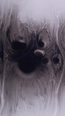 Dikey video. Boya lekesi. Sıçrama geçişi. Beyaz diş minesine siyah boya damlıyor. Monokrom sanat patlaması. Su soyut odaklanmış arka plan..