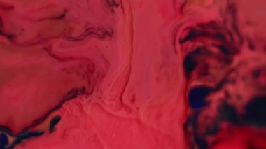 Dalgalanma lekeleri. Sıvı arka plan. Odaklanmamış turuncu pembe akrilik boya parlak su dokusu sanatın koyu siyah soyutlaması üzerinde akıyor..