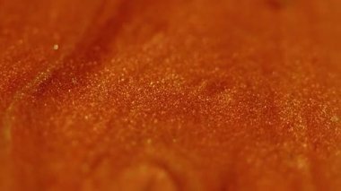 Işıltılı damlalar. Parlak arkaplan. Odaklanmamış turuncu altın rengi boya yağ lekeleri su sıvısı dokusu soyut sanat üzerine akıyor..