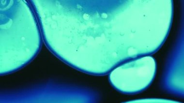 Moleküler arka plan. Sıvı floresan. Odaklanmamış mavi neon rengi su sıvı esans mürekkep damlası soyut sanat ışığı üzerine koyu siyah akış dökülür.