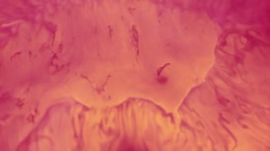 Mürekkep yayılıyor. Görüntü sıçraması. Soyut sanat eserlerinin arka planında çözünmüş pembe renkli su, sıvı boya damlası patlaması.