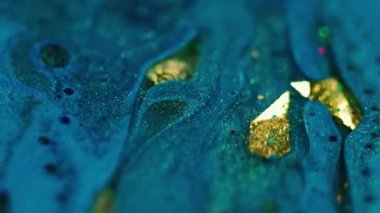 Işıldayan sıvı. Pırıl pırıl. Bulanık mavi kırmızı yeşil boya suda akıyor altın yağ yuvarlak daireler soyut bokeh arkaplan üzerinde.