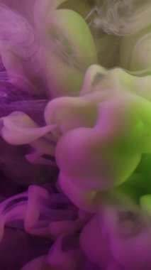 Dikey video. Sis bulutu. Dumanı karıştır. Mor yeşil boya sıvıya dökülüyor. Sanat karışımı renk girdabı patlaması soyut akış odaklanmamış arkaplan.