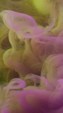 Dikey video. Duman patlaması. Haze girdabı. Soyut sıvıda sarı mor akış mürekkebi. Siyah arkaplanda odaklı olmayan renk damlası karışımı fantezisi.