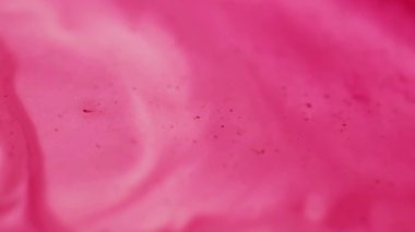 Dalgalı boya. Karışım akışı. Odaklanamayan pembe beyaz renkli su mermeri parçacıkları soyut sanat arka planında sıvı dokusunu yayıyor..