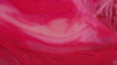 Parlak akışkan sıvı. Soyut mürekkep. Odaklanmamış kırmızı, mor renkli su parıltılı sıvı parçacıkları sanatın canlı arka planına dökülüyor..