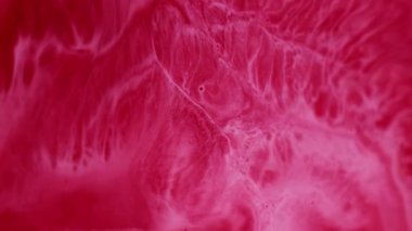 Dalgalı sıvı boya. Soyut lekeler. Odaklanmamış kırmızı renk, akrilik sanat arka planında akan su sıvısı emülsiyon ıslak parçacıkları sıçratır.