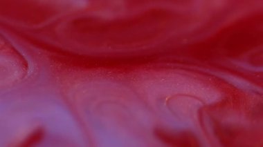 Karışık renk. Enamel sıvısı. Bulanık kırmızı boya akışı sıvı kırmızı emülsiyon lekeleri soyut akrilik arka planda yayılıyor..