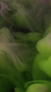 Dikey video. Renkli sis. Pigment dalgası. Neon mor boya sisi suda çözünüyor. Gizemli parlak duman soyut çözülmüş girdap karışımı arka plan.