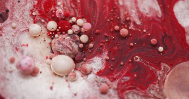 Akrilik kabarcıklar. Yağlı boya suyu. Odaklanmamış kırmızı beyaz pembe renkli canlı sim desenli sıvı akış sızıntısı soyut arka planda.