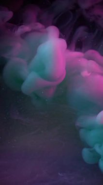 Dikey video. Sis dalgası. Koyu sis. Siyah gece geçmişinde mor gri duman spreyi fırtınası. Renkli sıvı boya soyut bulanık duman suya sıçramış..