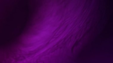 Akış karışımı. Dalga sıvısı. Odaklanmamış mor neon rengi su esansı parıldıyor siyah boya damlası mürekkep damlası sanat arkaplanına dökülüyor.