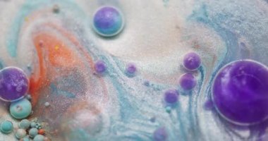 Mürekkep karışımı. Petrol emülsiyonu dökülüyor. Odaklanmamış mor turuncu renkli köpük parlatıcı deseni soyut bokeh arkaplanda yüzüyor..