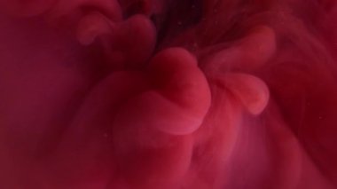 Bulut yayılıyor. Sis boyası. Odaklanmamış mor renkli sıvı harman dumanı yuvarlak sıçrıyor soyut koyu siyah arkaplanda daireler çiziyor.