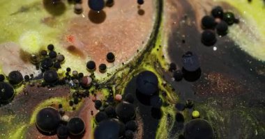 Yağ kabarcıkları. Parıltılı boya. Odaklanmamış sarı turuncu parlak siyah desenli su soyut Bokeh sanat arka planında yüzüyor..