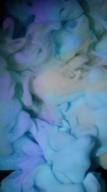 Dikey video. Bulut sıçraması. Buharı boya. Sanat sıvısında karıştırıcı mavi sarı dumanlı patlama. Siyah soyut odaklanmış arkaplan.