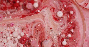 Yağ sıvısı. Boya sanatı. Odaklanmamış kırmızı pembe renk akışı ıslak kabarcık parlatıcı sıvısı soyut bokeh akrilik arka planda yayılıyor.