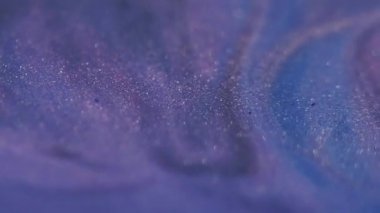 Parlak parçacıklar. Parlak sıvı. Bulanık mavi mor renkli mürekkep tozu. Soyut akrilik sanat arka planına yayılan koyu siyah lekeler..
