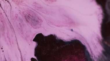 Yüzen parçacıklar. Soyut sanat. Dalgalı suda çözünmüş pembe renk boya akrilik ıslak doku yaratıcı arka planda akıyor.