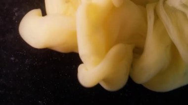 Sis karışımı. Sıvı pigmenti. Bulanık sarı mürekkep rengi duman dalgası soyut koyu siyah arkaplanda yüzen akrilik parçacıklar..