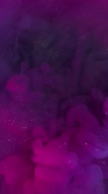 Dikey video. Parıldayan duman. Sanat buharı. Mor menekşe parıldayan duman akışı, neon boya parıltısını karıştırıyor. Odaklanmamış renk mürekkebi soyut arkaplanı sıçratır.