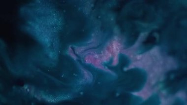 Petrol dökülüyor. Soyut lekeler. Odaklanmamış mavi renk akışı su sıvısı parlak parçacıklar sanatın karanlık arka planına yayılıyor..