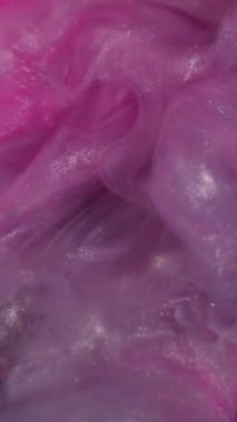 Dikey video. Duman sıvısı. Buharı boya. Pembe su rengi pigment dalgası soyut mor gümüş parıldayan arkaplanı harmanlıyor. Buhar fantazisi köpüklü boya.