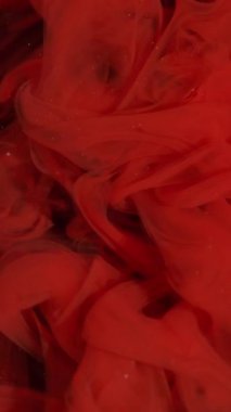 Vertical video. Mist wave. Fog ink swirl. Red paint blending in art defocused fluid. Hypnotic sparkling stream color abstract black background.