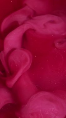 Vertical video. Smoke explosion. Fume paint. Pink wave pigment spill in red sparkling water. Color stream dye defocused dissolve abstract background.