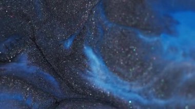 Parlak doku. Renkli mürekkep dalgası. Odaklanamayan mavi parlak pigment koyu siyah parçacıklar soyut akrilik sanat yaratıcı arka plana dökülüyor.