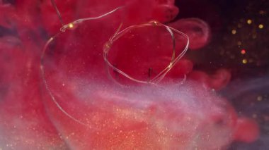 Parlak bir bulanıklık. Parlayan ampul. Kırmızı beyaz sis karışımı mürekkep sıvıda. Parıldayan renk soyut siyah arkaplan üzerine çelenk.