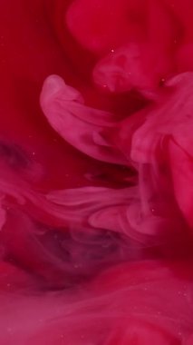 Vertical video. Magic fume. Paint blend. Pink red swirl mystery stream. Color pigment dissolving art defocused abstract background shimmering wave.
