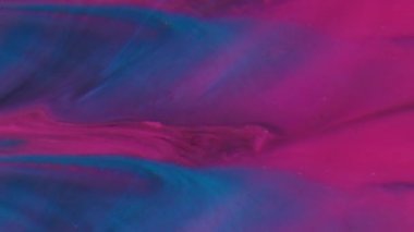 Mürekkep akışı. Neon arka plan. Yaratıcı akrilik soyutlama üzerine yayılan mor mavi renkli simli partiküller..
