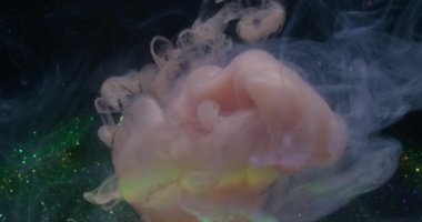 Duman suyu. Mürekkep sıçraması. Odaklanmamış pembe yeşil renkli kıvrımlı gökkuşağı parıldayan sis soyut koyu renkli neon bokeh arkaplan üzerindeki ampulü kırdı.