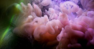 Sis sanatı. Atmosferik duman. Soyut arkaplanda yüzen kimyasal ışıltılı suda bulanık pembe sarı renkli bulut boyası..