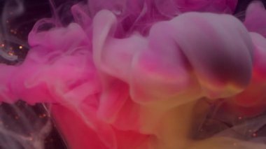 Boya girdabı. Odaklanmamış duman dalgası. Pembe turuncu gri sis karışımı mürekkep sıvıda. Işıldayan renk arkaplanında parlak bir çelenk.