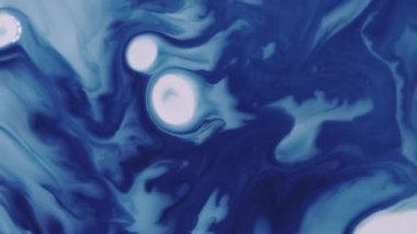 Boya serpintisi. Sıçrama dokusu. Çözünmüş mavi beyaz renkli su damlası lekesi soyut yaratıcı akrilik arka planda yayılıyor..