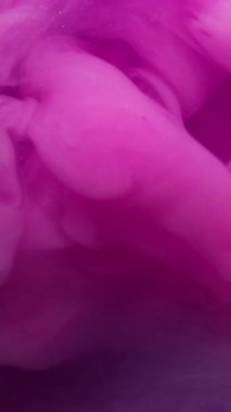 Dikey video. Renkli duman kokusu. Pigment karışımı. Pembe mor boya karışımı bulut. Parlak dalga boyası patlama sıvısı, arkaplan bulanık dokusu.
