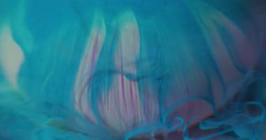 Boya yayılmış. Odaklanmamış döküm. Mavi boya emülsiyonu beyaz mor kürenin üzerine dökülüyor. Renk sıvısı harmanlama akışı su altında soyut arkaplan.