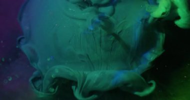 Boya döküldü. Bulanık boya dalgası. Parlak yeşil akrilik sıvı sanat küresinin üzerine dökülüyor. Renkli su titreşimli karışık soyut arkaplan.