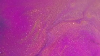 Bulanık mürekkep akışı. Parlak pigmentler. Soyut arkaplana yayılan mor pembe altın renkli simli partiküller..