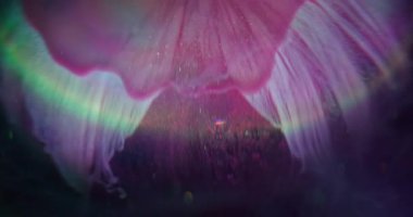 Sızdıran sim. Odaklanmamış sanat sıçraması. Işıldayan pembe akış topu. Soyut arkaplan gökkuşağı parlamasında renkli boya çözünüyor.