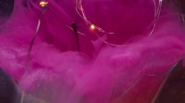 Buhar karışımı çözüldü. Kırık ampul. Fişek çelengine renk dumanı dökülmüş. Sarı parıltılı, soyut siyah arkaplanda pembe dumanlı boya karışıyor..