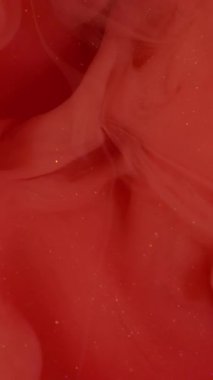 Dikey video. Sis dalgası. Buhar mürekkebi. Su zeminine yayılmış parlak kırmızı sıvı girdap. Bulanık renk soyut ışıldayan pigment canlı sıçrama karışımı.